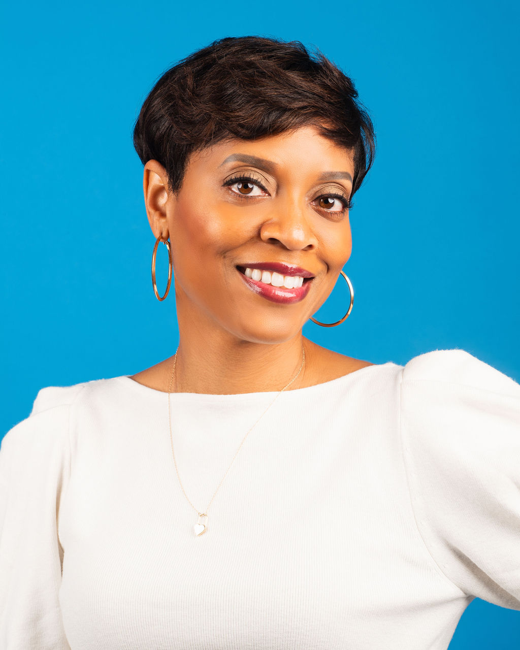 farrah with short hair and wearing a white shirt, smiling